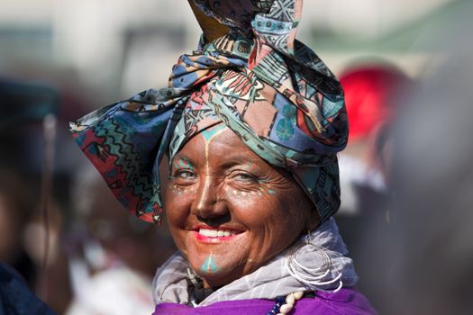 Colorful portrait of a smiling woman in traditional attire, capturing the joy and vibrancy of a cultural festival.