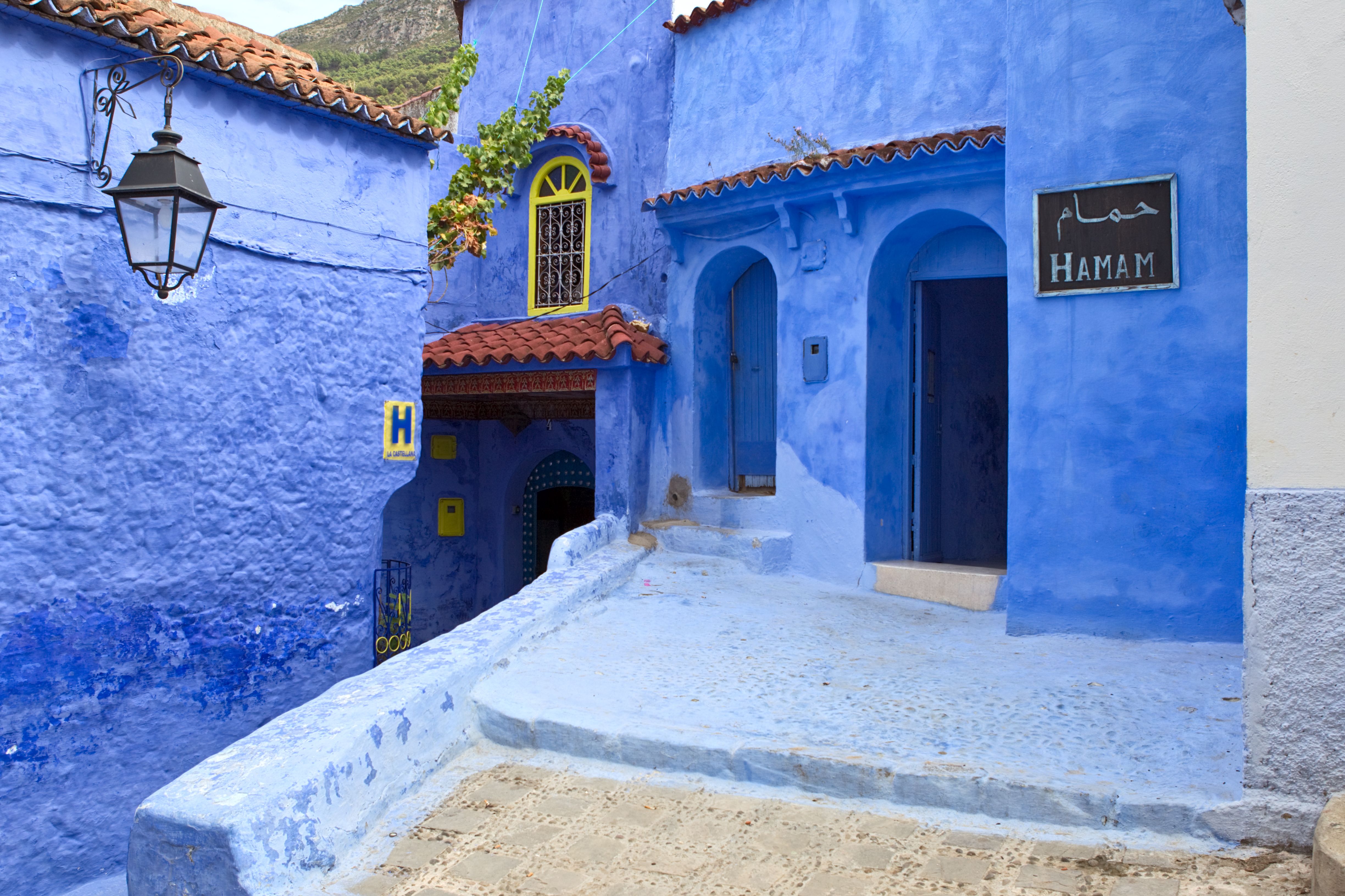 Charming blue-painted street in Chefchaouen, Morocco. Features vivid walls and intricate doorways.