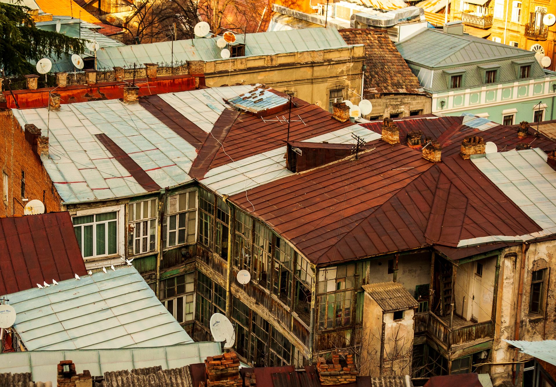Charming aerial view of rustic rooftops adorned with satellite dishes, representing urban lifestyle.