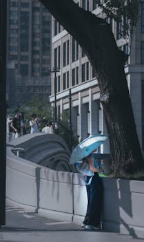 A person relaxes under an umbrella in a quiet city street, offering a moment of calm.