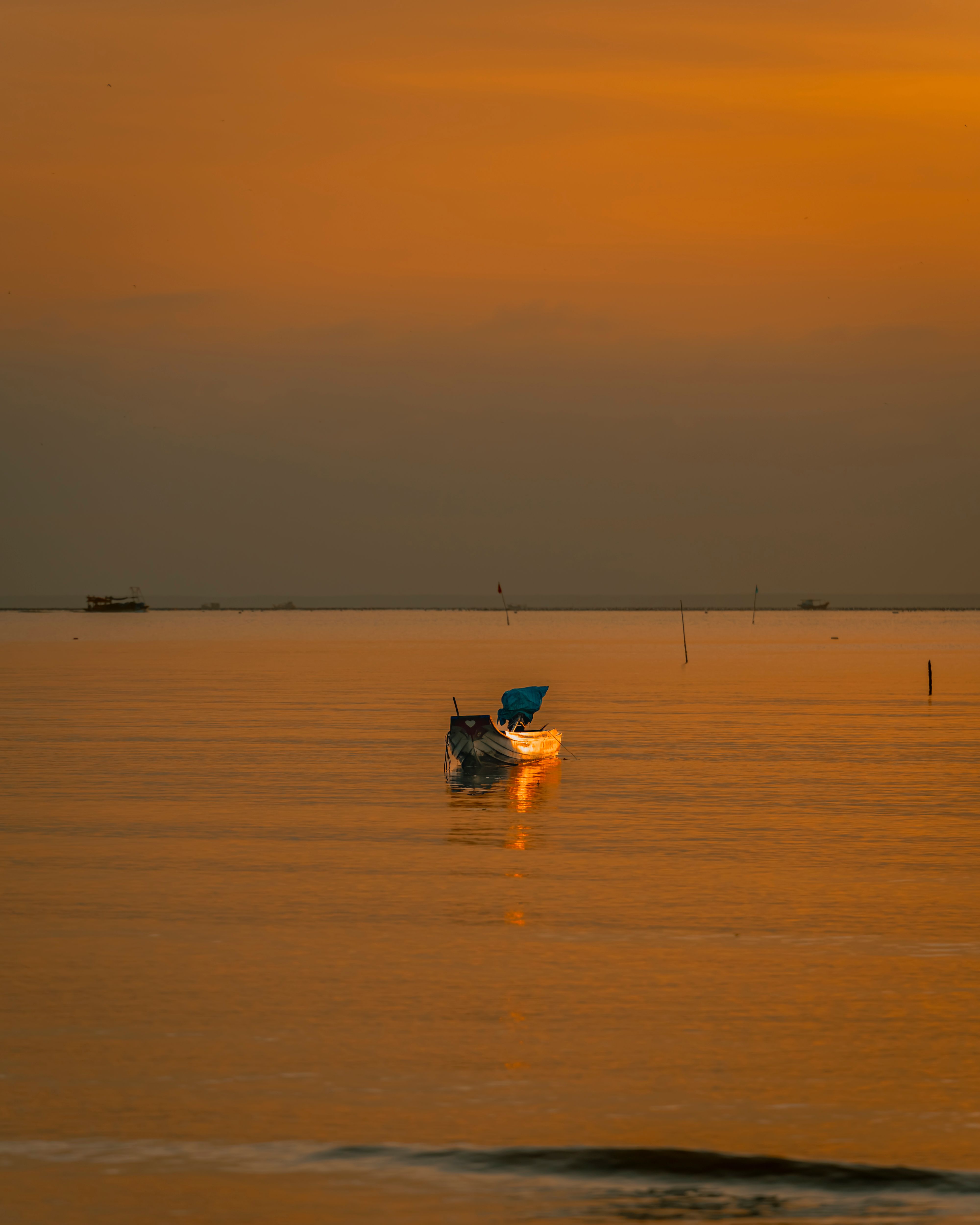 Serene Sunset Scene with Fishing Boat on Calm Sea · Free Stock Photo