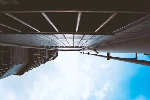 Free Striking architectural perspective of a towering building reaching into a clear blue sky. Stock Photo