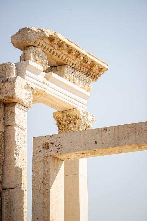 Free Close-up of an ancient stone structure with ornate detailing under a clear sky. Stock Photo