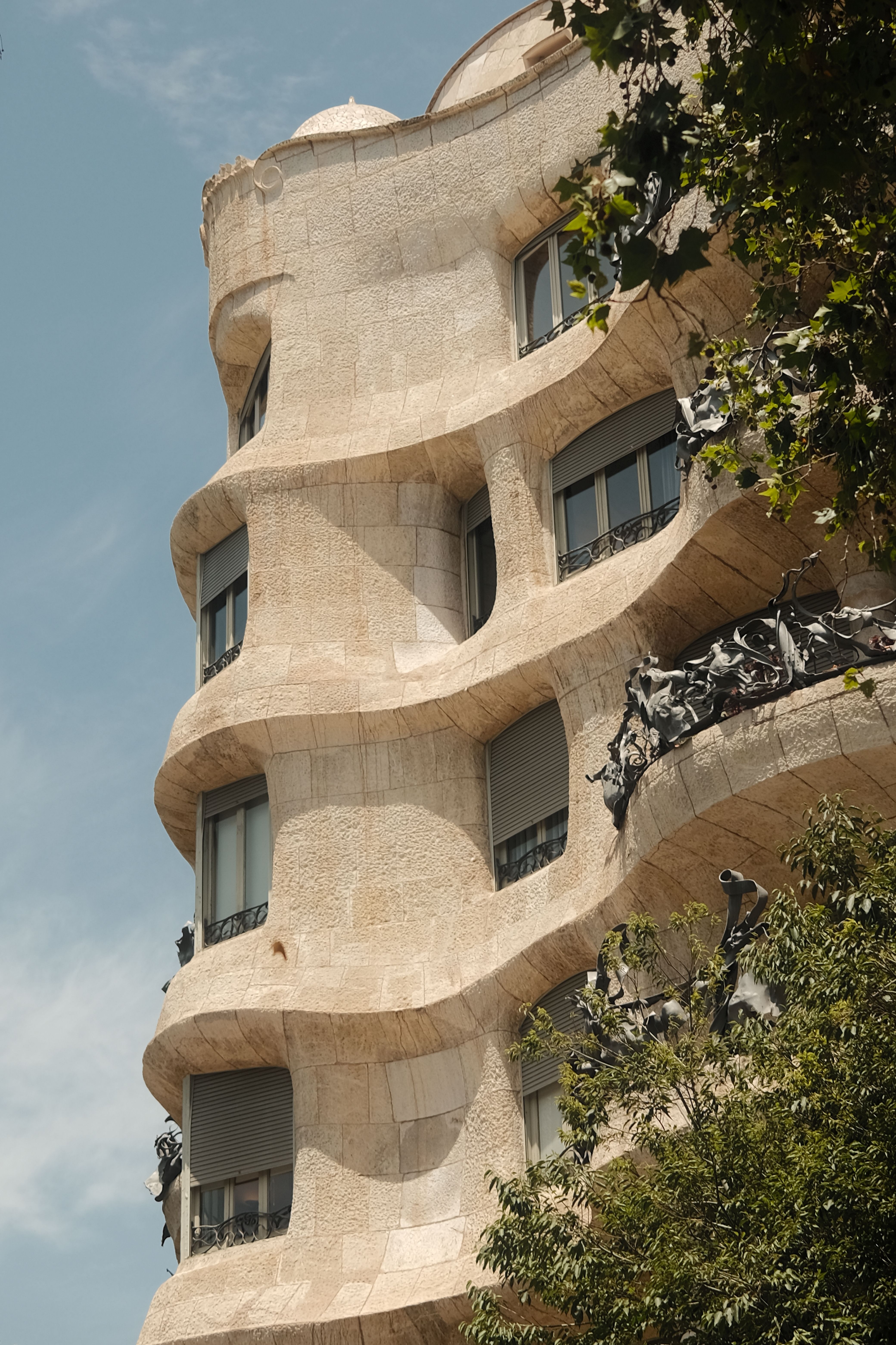 Explore the wavy stone facade of Antoni Gaudí's famous Casa Milà in Barcelona.