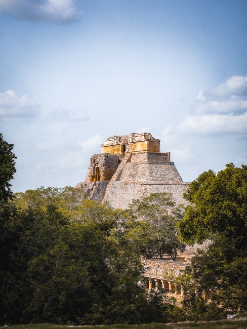 Free Explore the iconic Pyramid of the Magician in Uxmal, Yucatán, surrounded by lush greenery and blue sky. Stock Photo