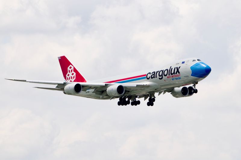 Cargo airplane in mid-air flight above the clouds