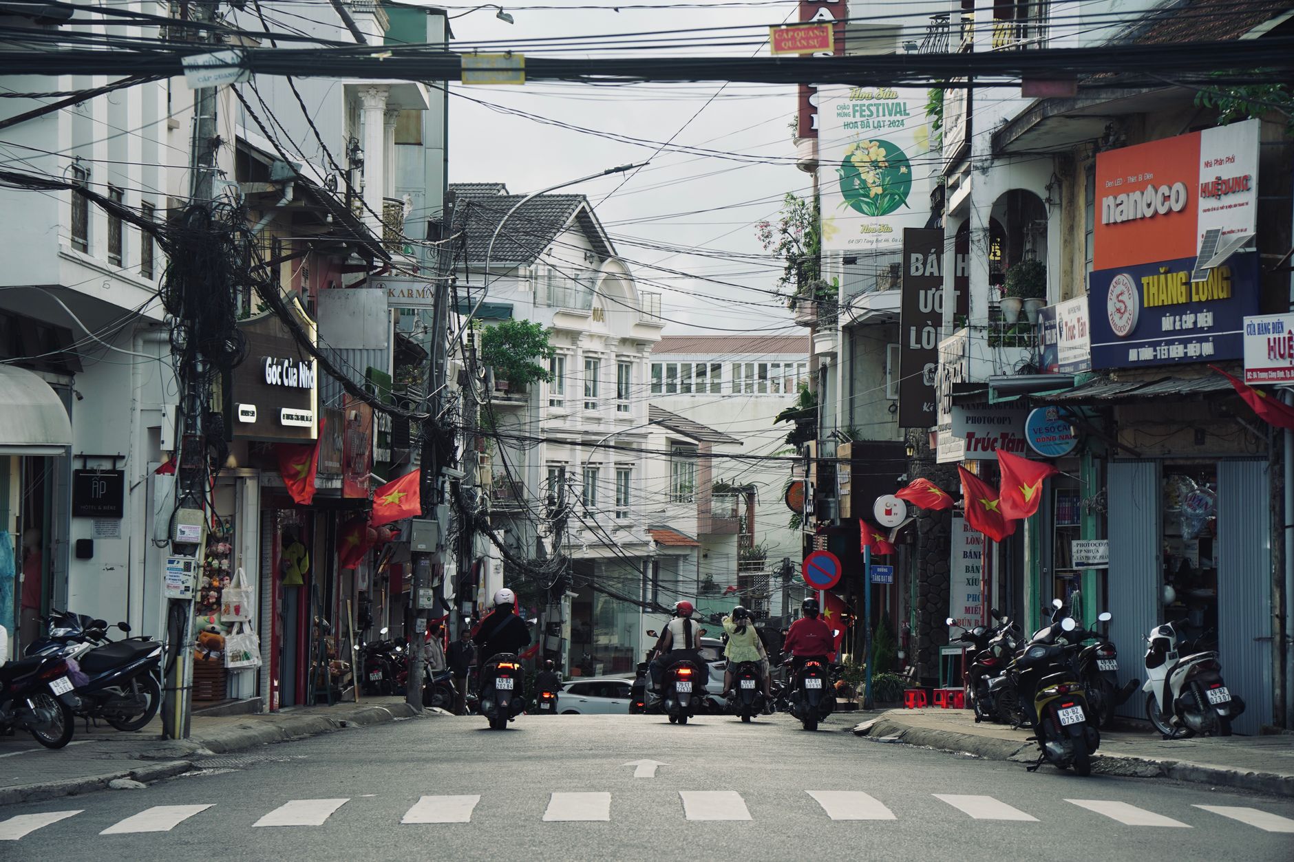 Vibrant street view in Vietnam showcasing motorcycles, bustling shops, and urban life.