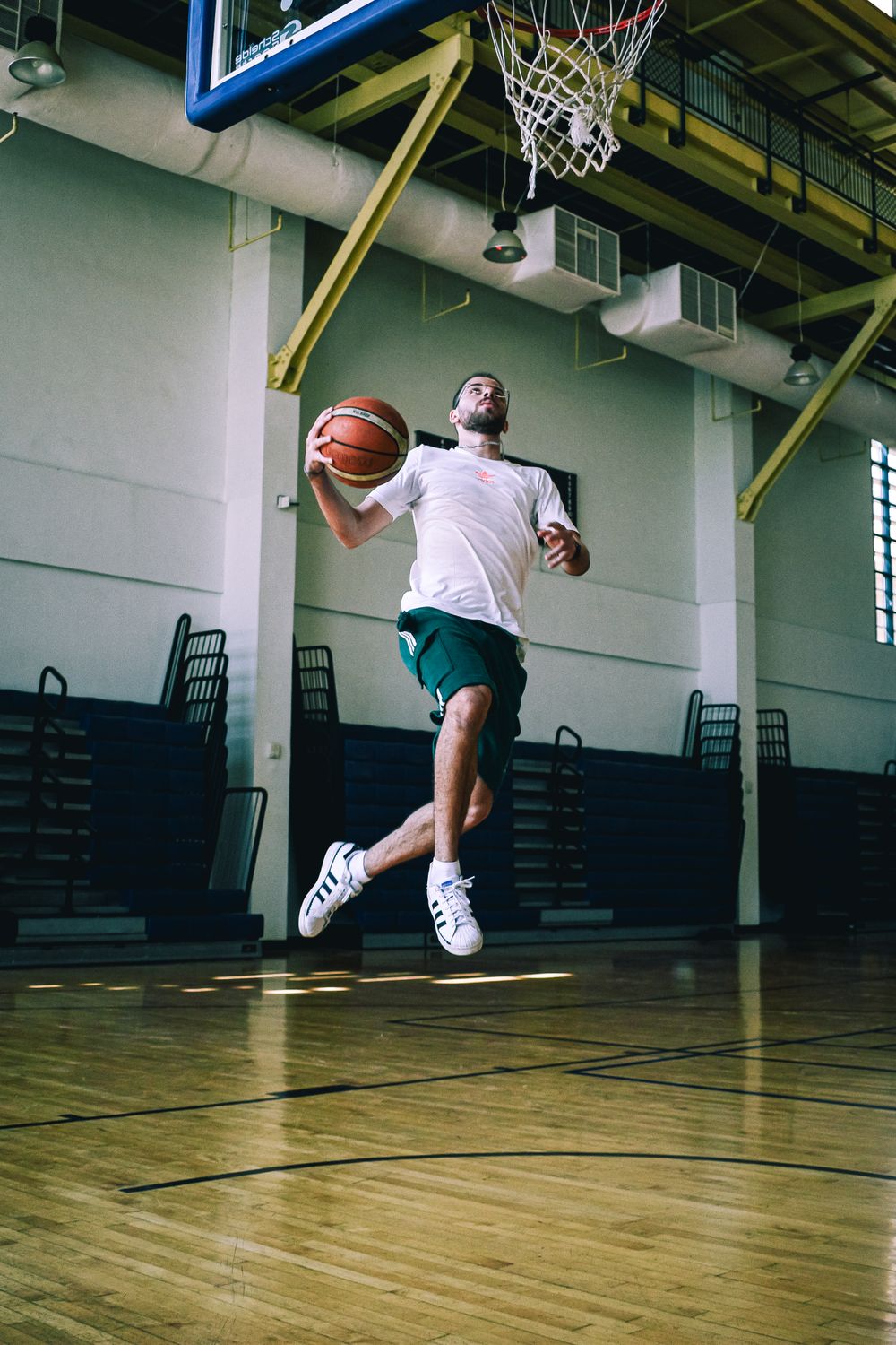 Athlete poised to dunk a basketball in a well-lit indoor court