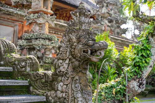 Free Detailed stone dragon sculpture in a traditional Balinese temple garden, rich in cultural artistry. Stock Photo
