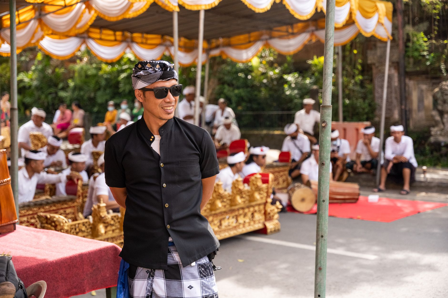 A Balinese cockfight arena in Ubud, Indonesia, surrounded by villagers under warm afternoon light