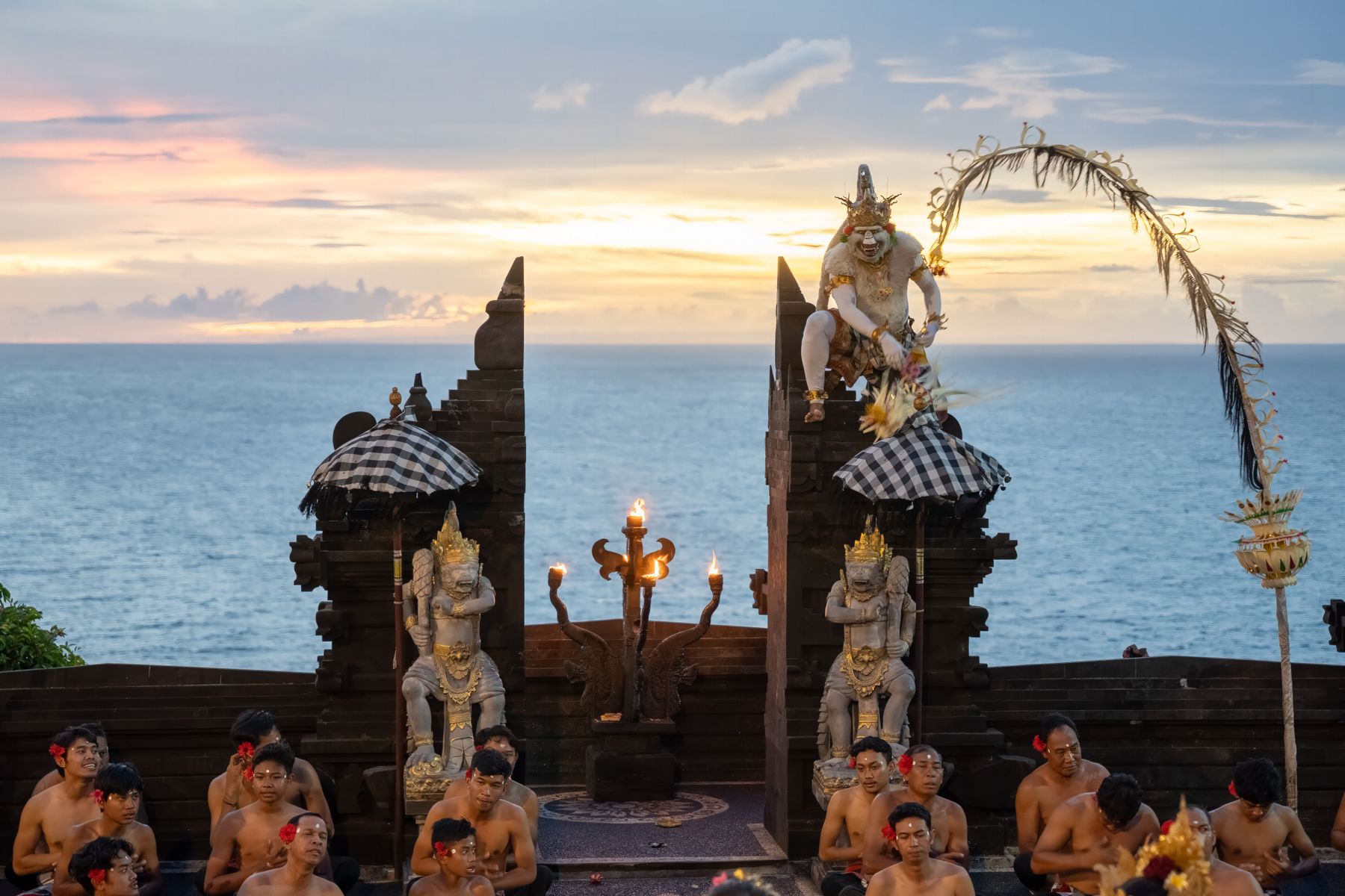 Kecak dancers performing at Uluwatu Temple above the coast at sunset