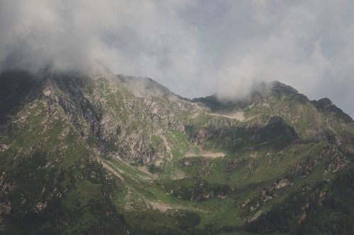 Free Dramatic view of green mountain peaks enveloped by clouds, showcasing nature's beauty. Stock Photo