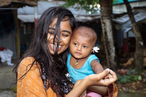 Free Joyful portrait of a woman and baby smiling outside in Manikganj, Bangladesh. Stock Photo