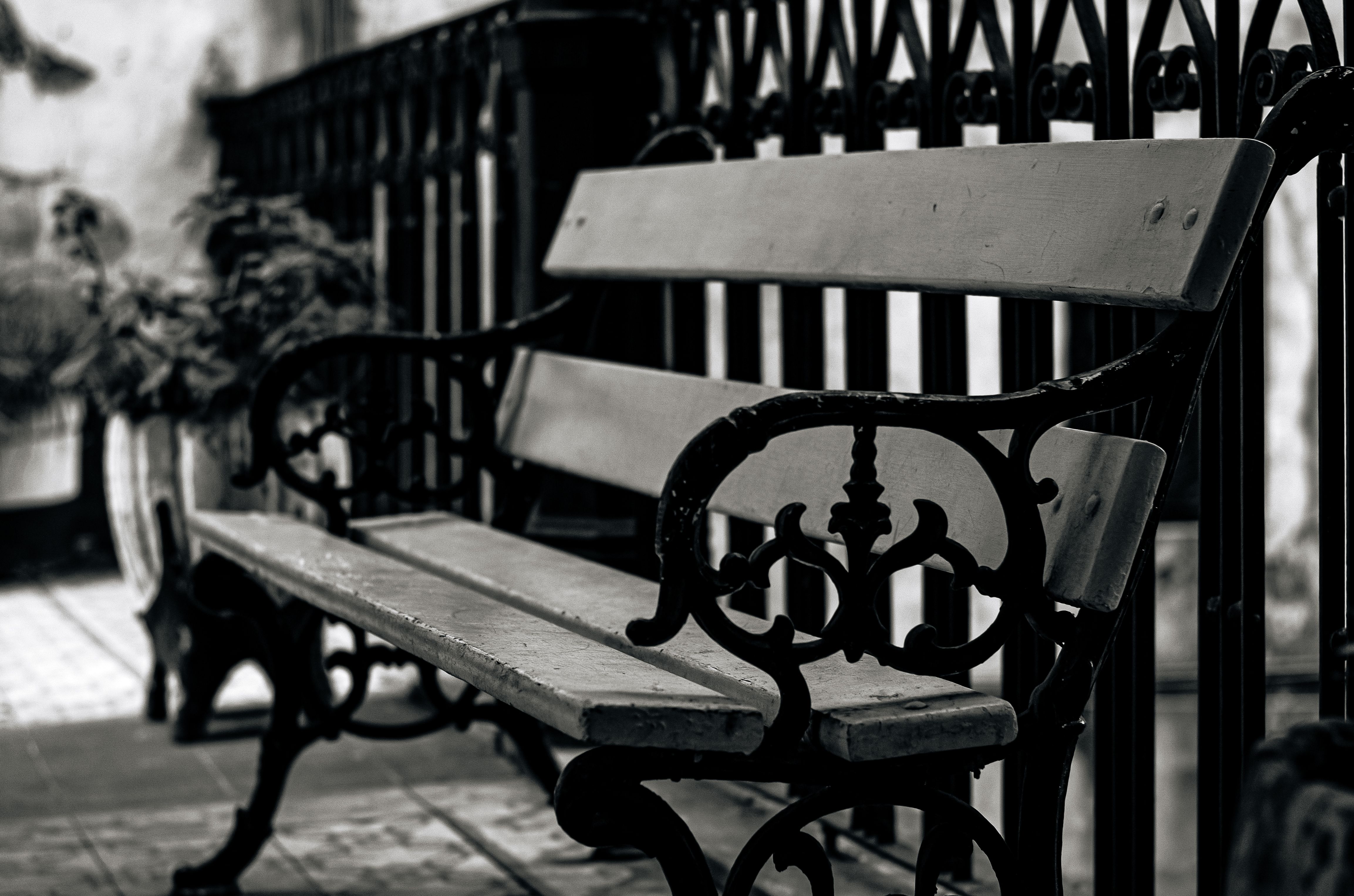 A black and white photo of a vintage iron bench on a balcony in Buenos Aires, Argentina.
