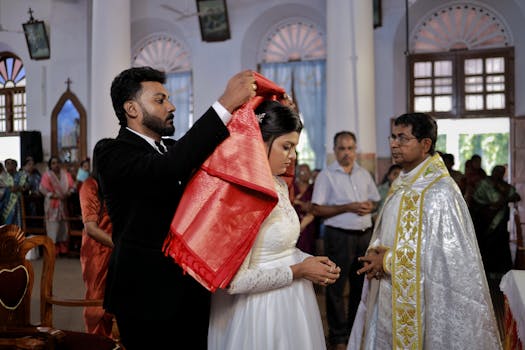 A South Asian groom placing a red shawl on the bride during a Kerala wedding ceremony.