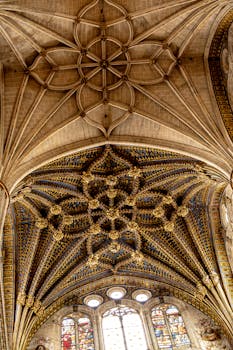 Stunning Gothic cathedral ceiling with detailed ribbed vaults and stained glass windows.
