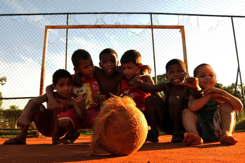 Crianças jogando futebol em campo comunitário no Rio de Janeiro