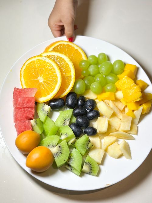 Free Colorful fruit plate with sliced kiwi, oranges, grapes, apples, and more, perfect for health-focused themes. Stock Photo
