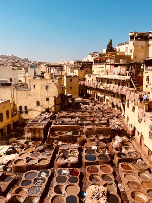 Free Vibrant view of ancient leather tanneries in Fez under a clear blue sky. Stock Photo
