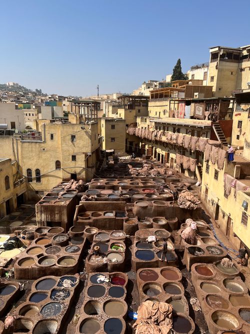 Free Aerial view of Chouara Tannery in Fez, Morocco, with vibrant dye vats under a clear blue sky. Stock Photo
