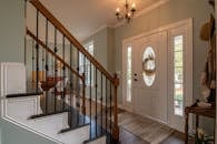 Brown Wooden Staircase With Brass Chandelier