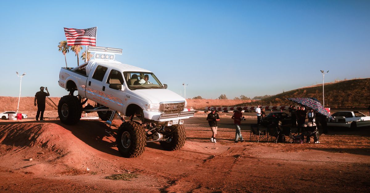 A lifted truck off-road adventure during a sunset event, capturing excitement and community spirit.