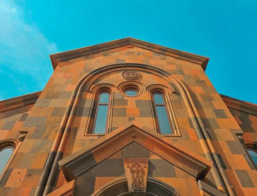 Free Low angle view of a historic building's intricate facade against a clear blue sky. Stock Photo