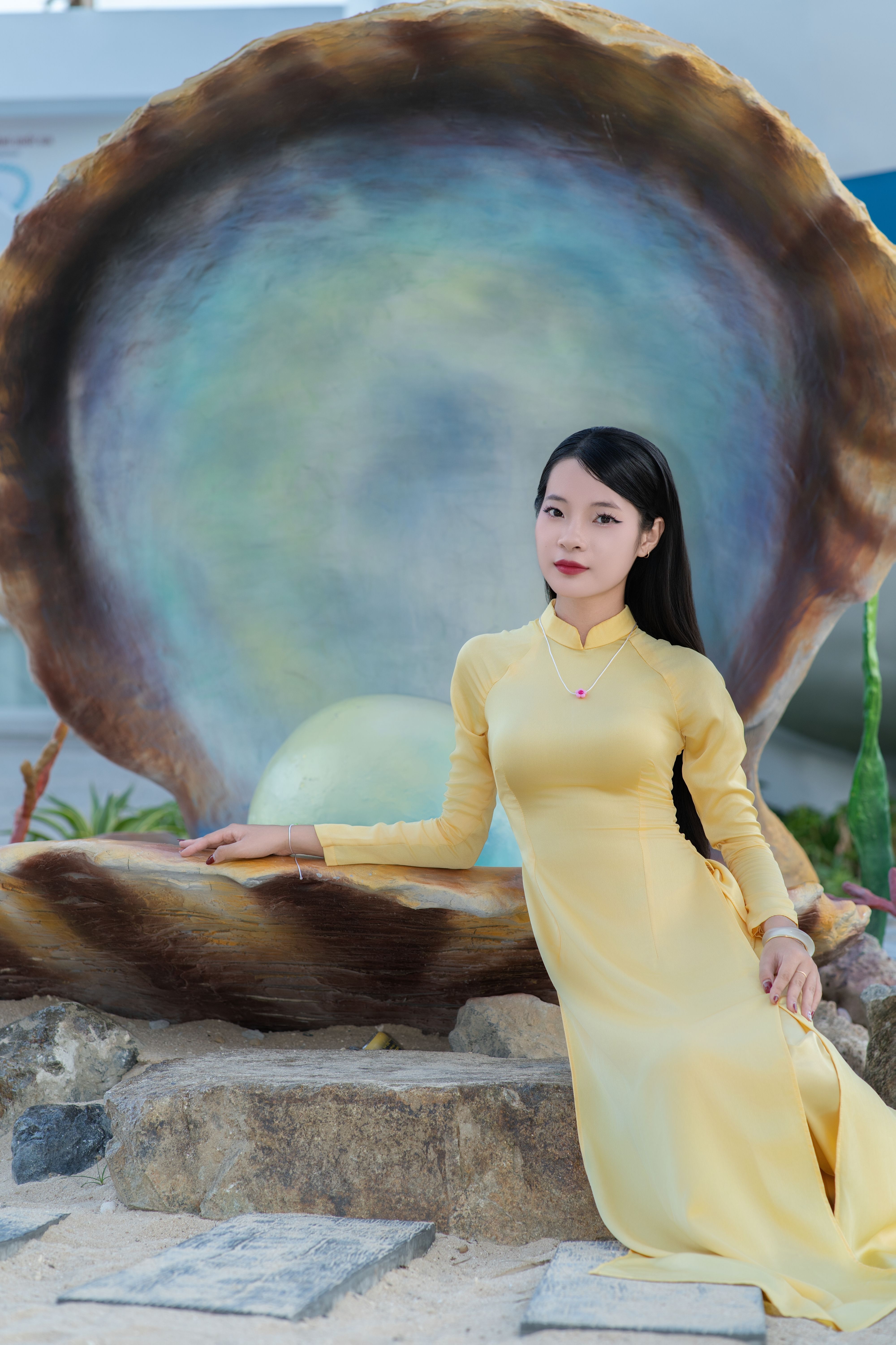 Young Woman in Yellow Dress by Giant Shell Sculpture · Free Stock Photo
