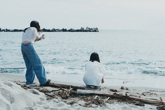 Two young adults enjoying a day by the sea at Nishi-Izu, Japan, capturing the serene beach scenery.