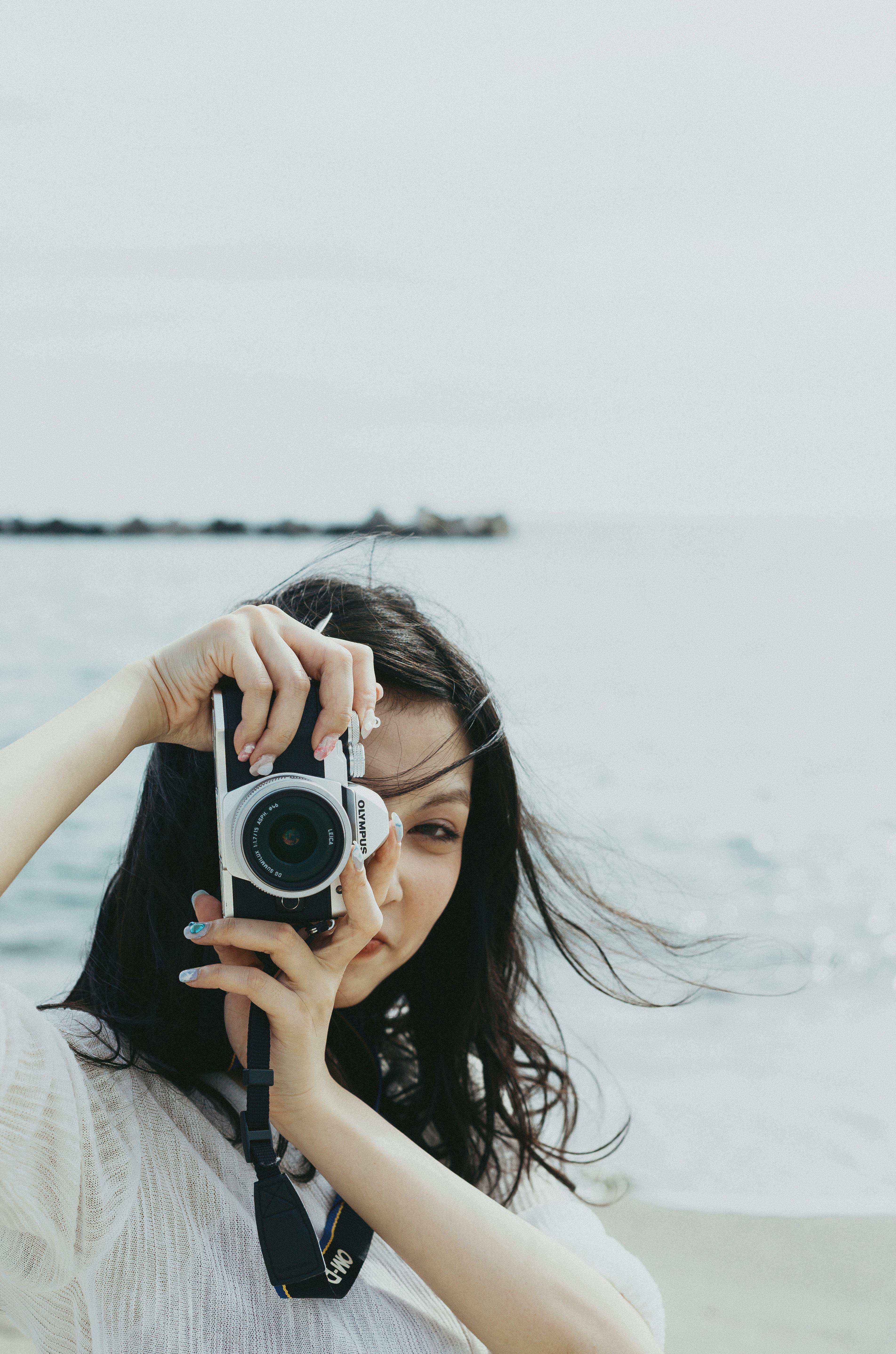 A young woman captures the beauty of the Japanese seaside with her camera.