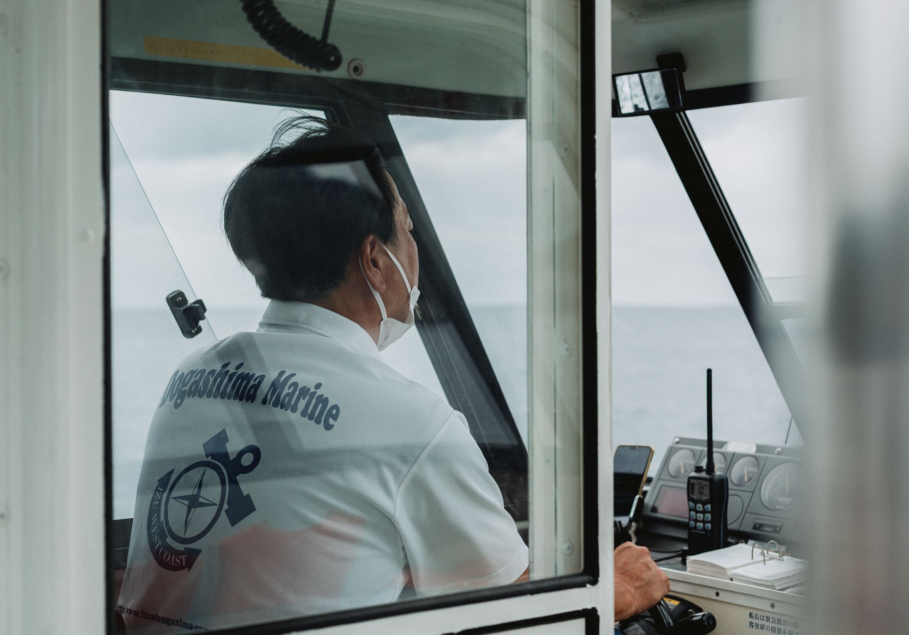 A boat captain navigating through the waters near Nishiizu, Shizuoka, Japan.