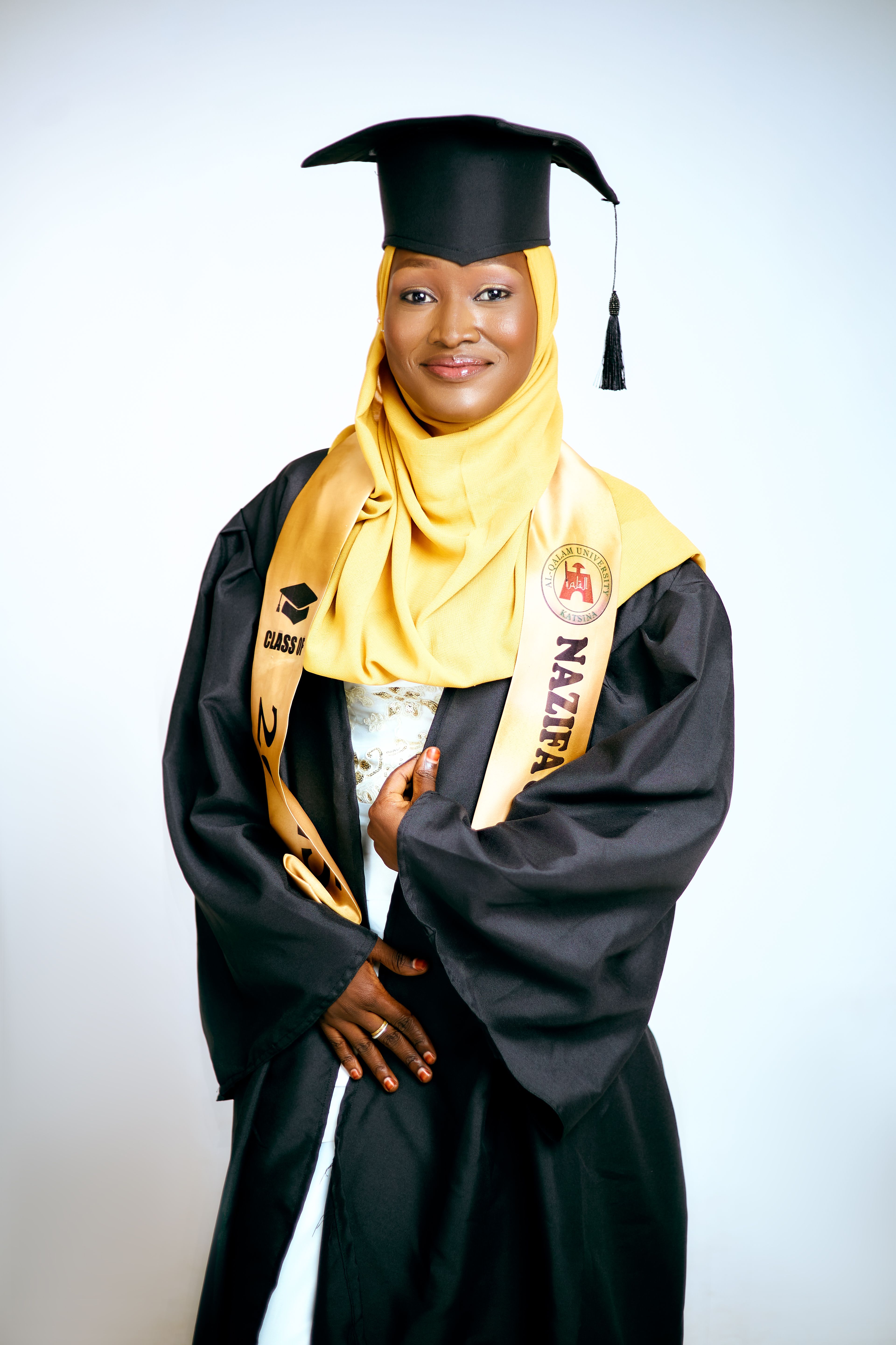 Young woman in cap and gown smiling confidently at the camera.