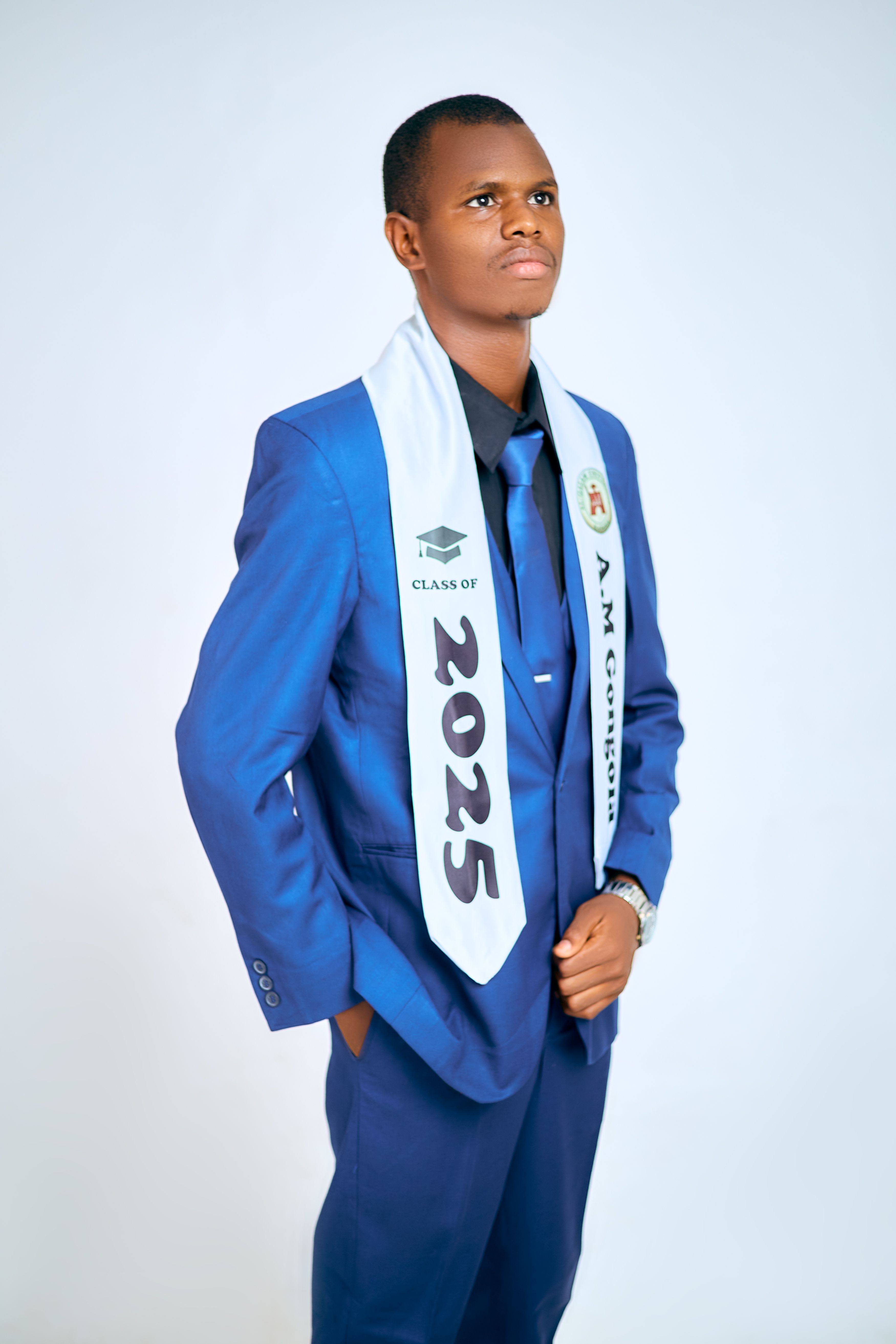Graduate in blue suit with a 2025 sash, symbolizing achievement and future aspirations.