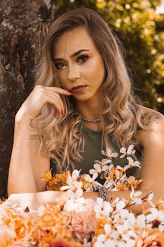 一位时尚女性留着金色长发，在鲜花环绕的户外摆着姿势