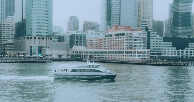 Ferry boat sailing across the Hudson River with New York City skyscrapers in the background.