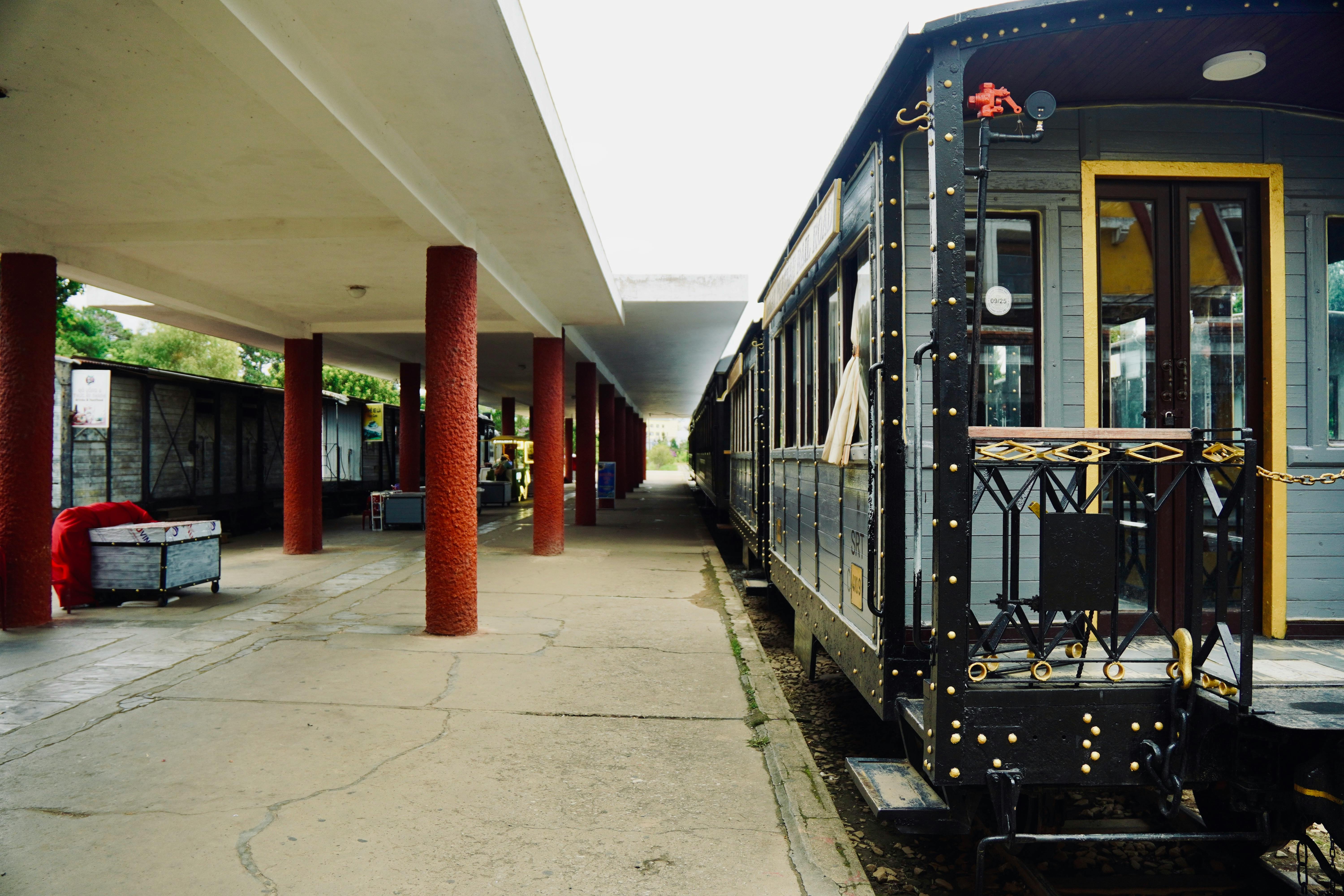 A vintage train parked at an empty railway station with a classic design and retro ambiance.