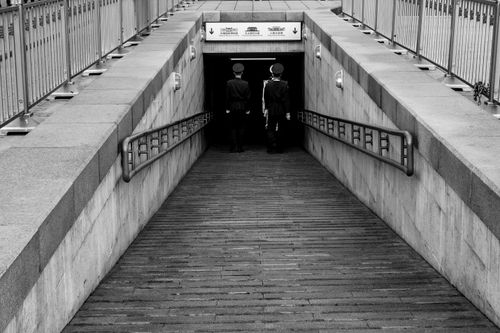Free Black and white photo capturing two guards entering a tunnel in Beijing, China. Stock Photo