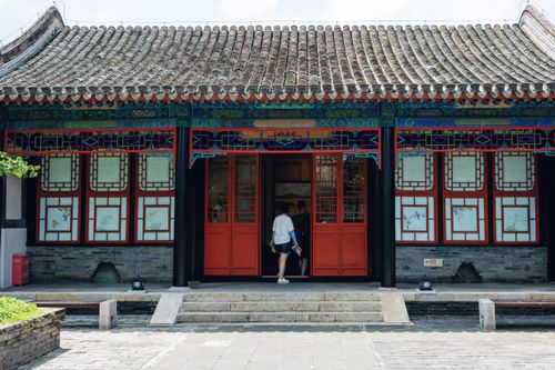 Free A person entering a traditional Chinese building with intricate wood carvings. Stock Photo