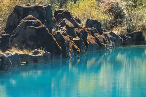 Free Tranquil blue water and rugged rocks create a serene landscape scene. Stock Photo