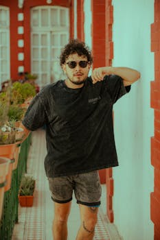 Young man in casual wear walking down a colorful urban corridor, expressing modern lifestyle.