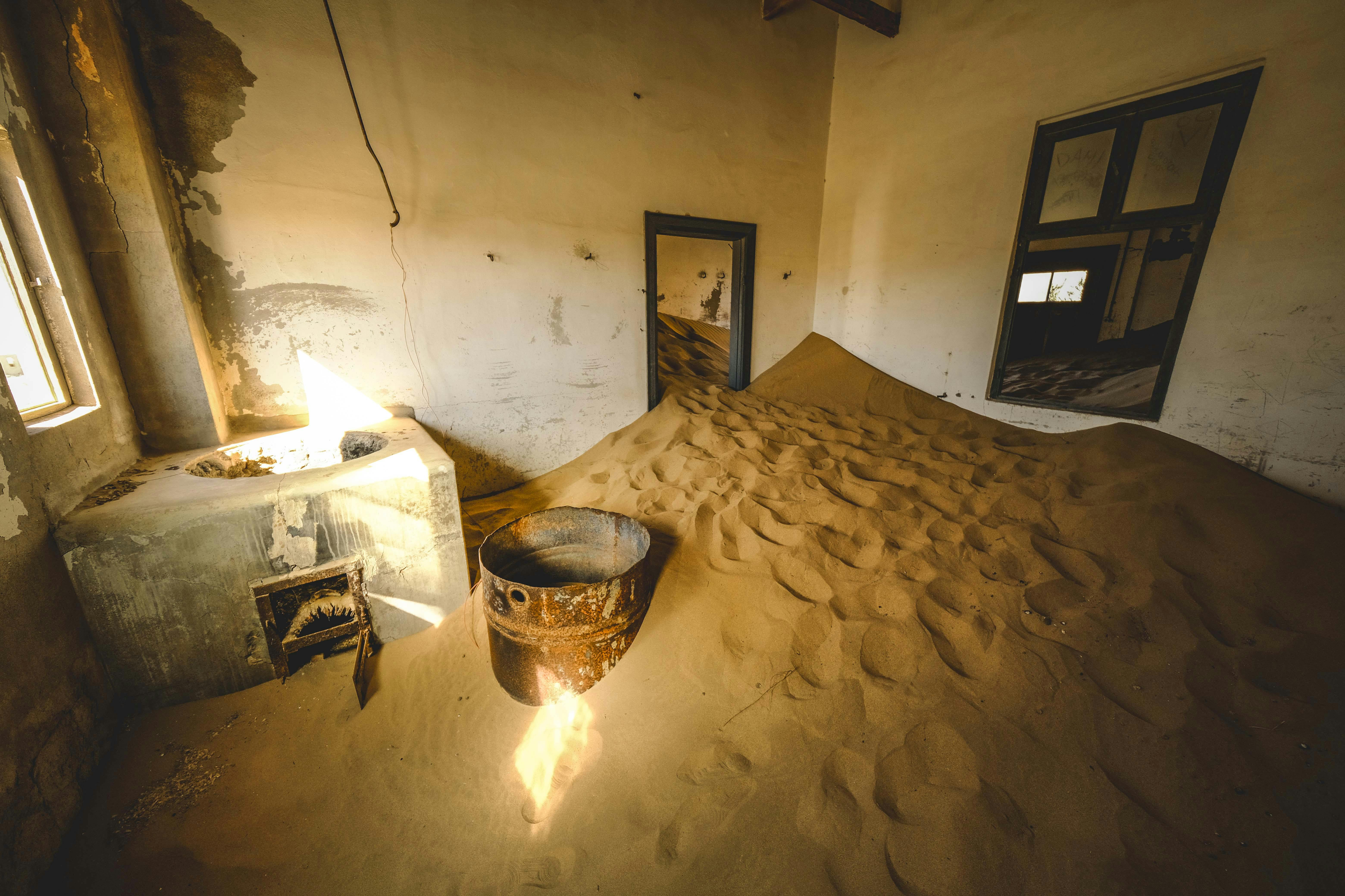 Intérieur d'une maison abandonnée à Kolmanskop, envahie par les dunes de sable du désert du Namib.