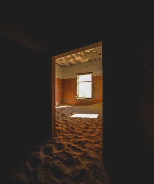 Free Eerie abandoned room in Kolmanskop, Namibia, overtaken by sand dunes. Stock Photo