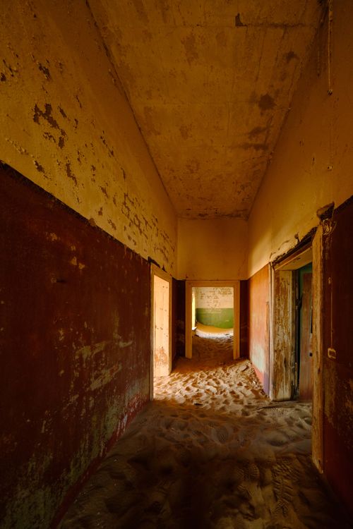 Free Sandy interior of an abandoned house in Kolmanskop, Namibia highlighting desert takeover. Stock Photo