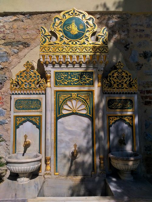 Free Intricate Ottoman stone fountain with Arabic inscriptions and golden details in Istanbul, Turkey. Stock Photo