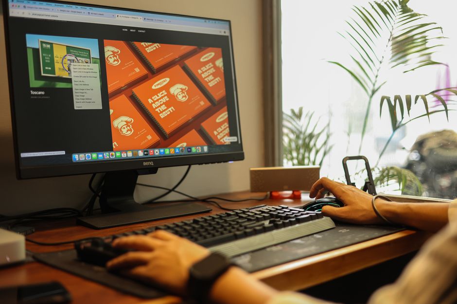 Hands working on a computer in a modern office setting, showcasing a focused and productive environment.