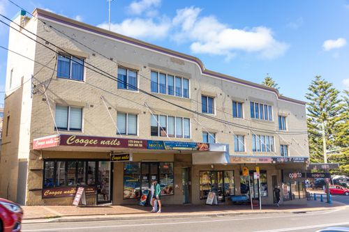 Free Street view of Coogee shops and apartments under a clear sky featuring local businesses. Stock Photo