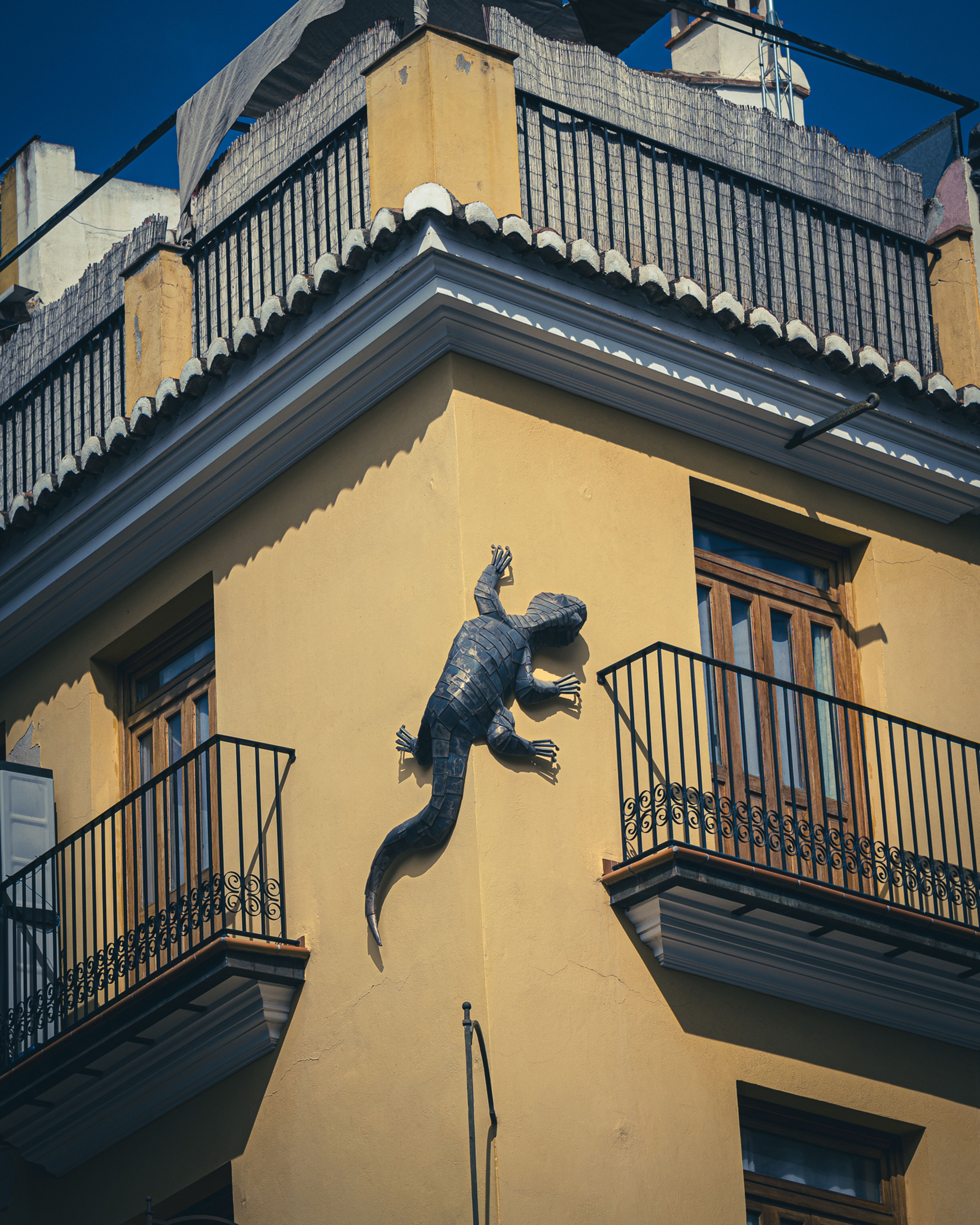 Sculpted Lizard on Urban Yellow Building Corner · Free Stock Photo