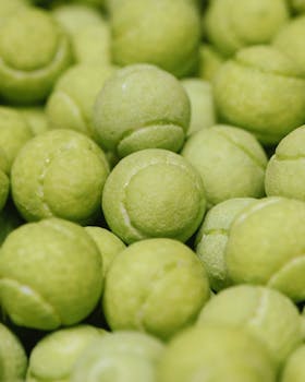 Detailed close-up of numerous green tennis balls, showcasing sporty texture and vibrant color.