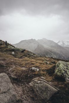 A moody view of rugged mountains in Finkenberg, Tyrol under cloudy skies.