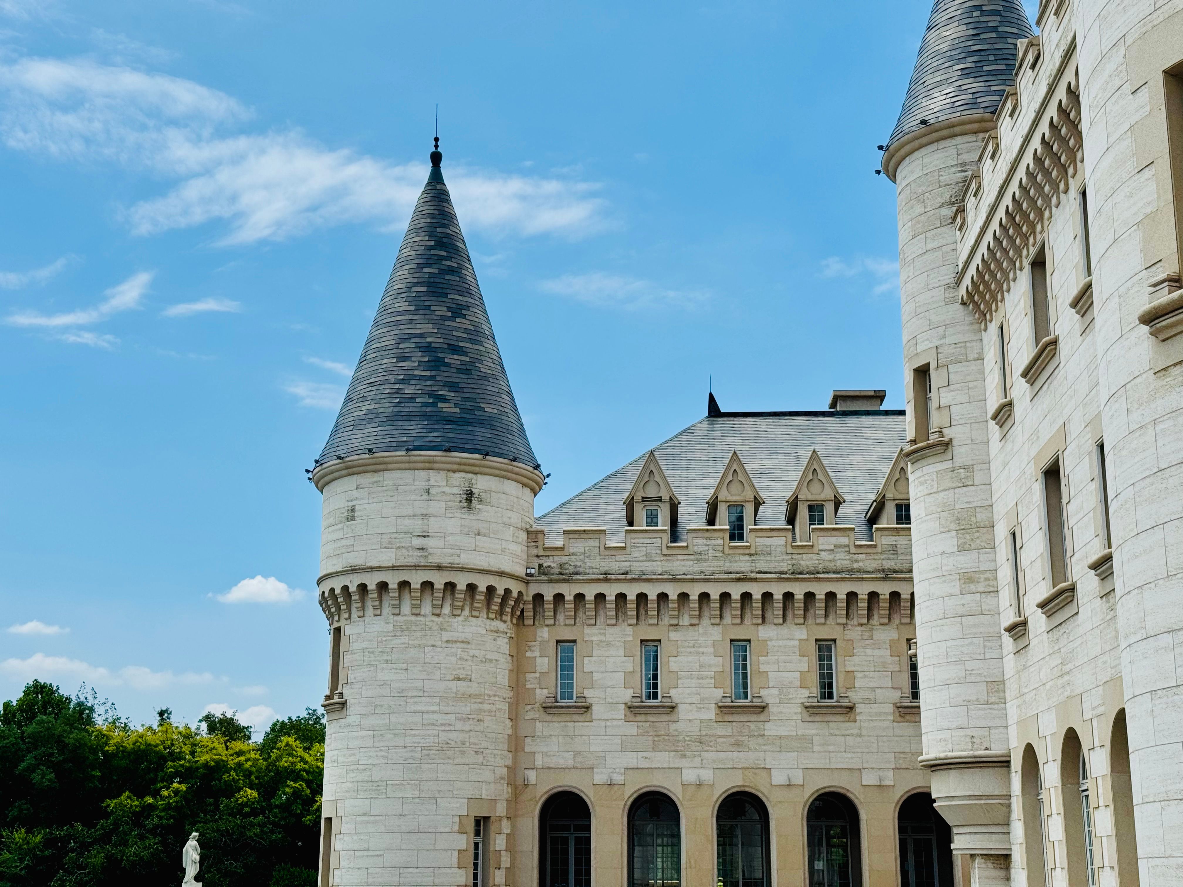 A stunning view of a European-style castle with turrets on a clear summer day.